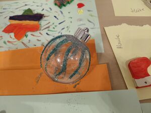 Eine gestaltete Glaskugel liegt auf dem Tisch.