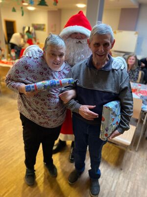 Der Nikolaus mit zwei Gästen die Geschebke haben.