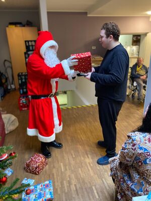 Der Nikolaus übergibt ein Geschenk.