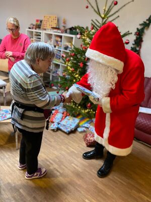 Der Nikolaus gibt einer Person die Hand.