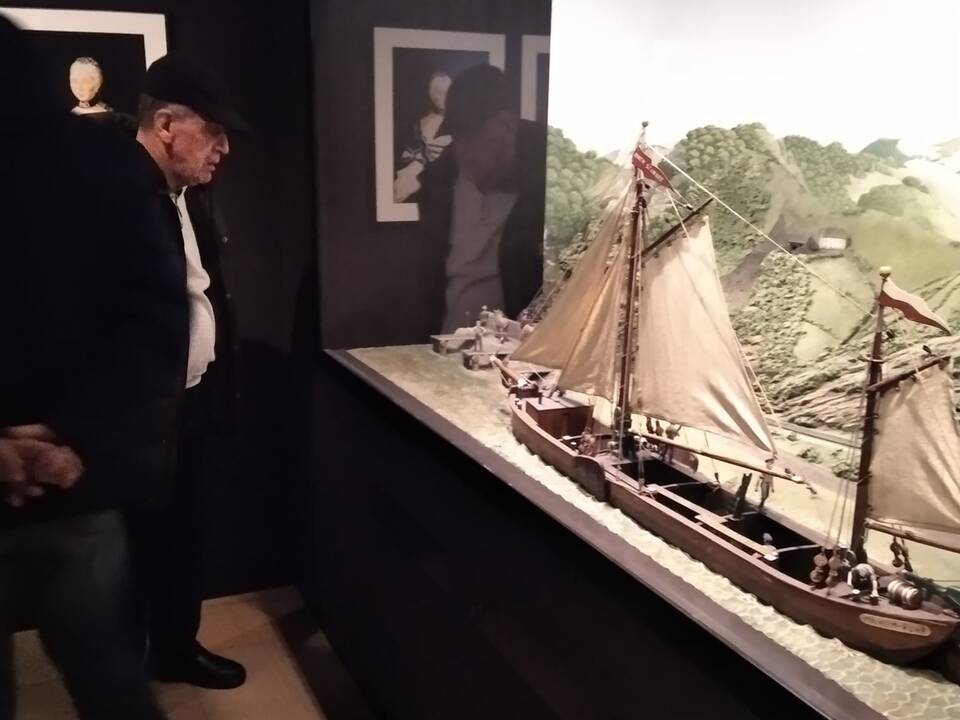 Eine Person vor einem Modellschiff.