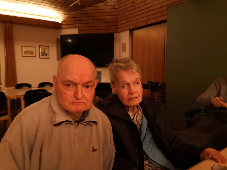 Ein Mann und eine Frau sitzen in einem Raum.