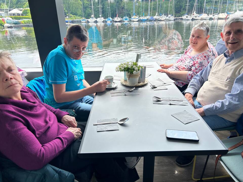 Vier Personen sitzen am Tisch.