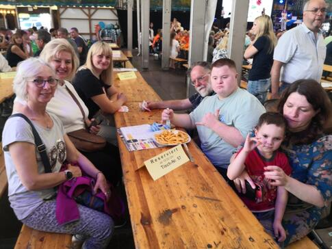 Mehrere Personen sitzen an einem langen Tisch.