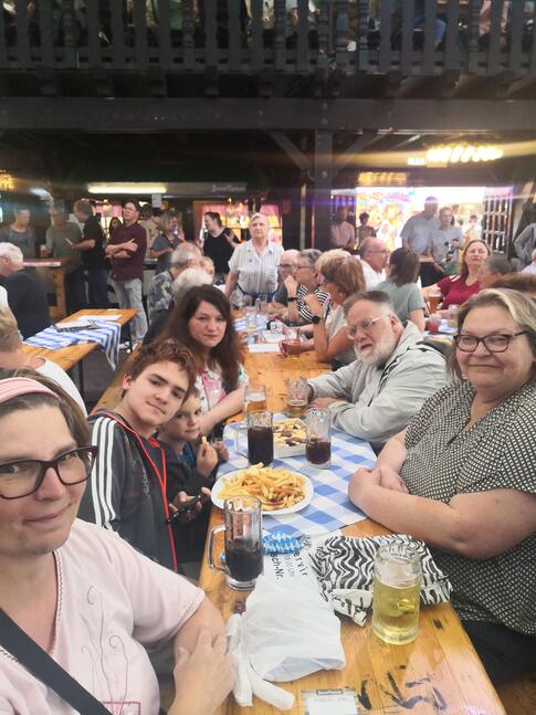 Viele Personen sitzen an einem langen Tisch.