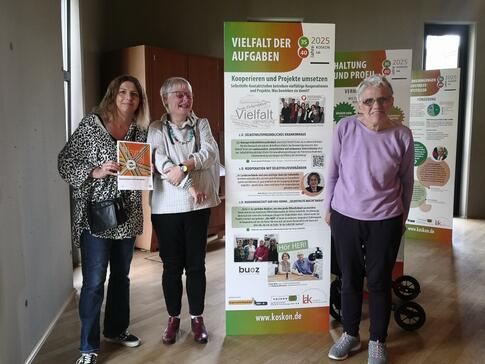 Drei Frauen stehen neben einem Banner von Koskon.