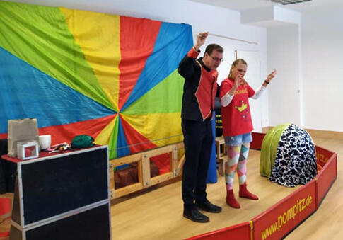 Zwei kostümierte Personen auf einer Bühne.