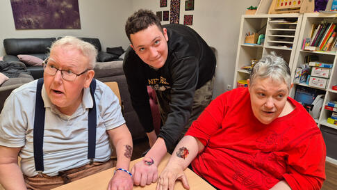 Drei Personen mit Klebetattos.