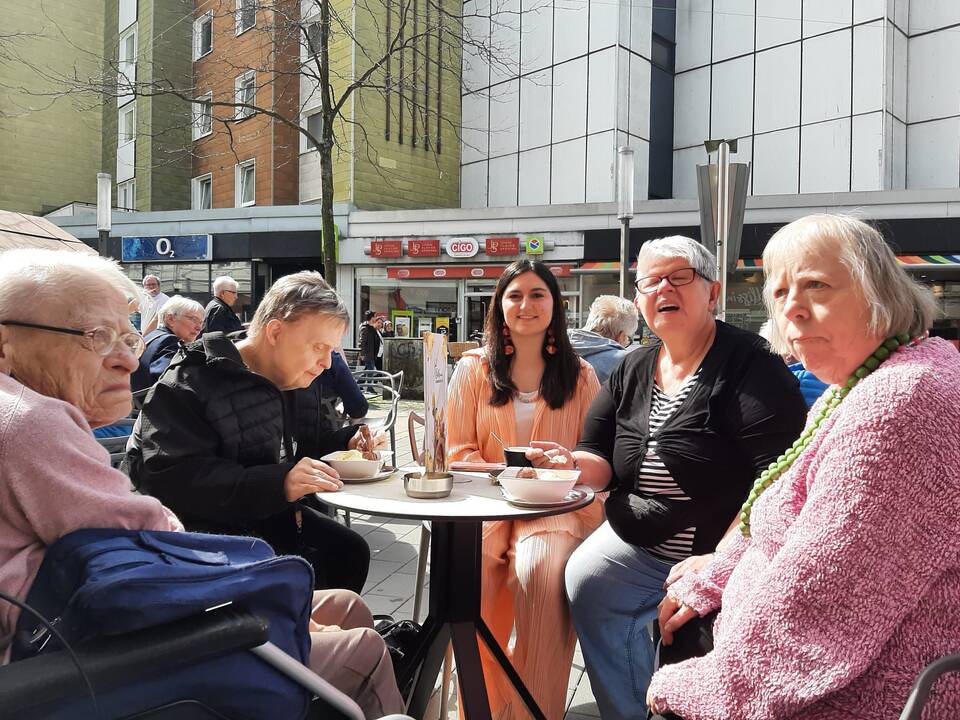 Bild zwie zeigt eine Gruppe Menschen vor der Eisdiele