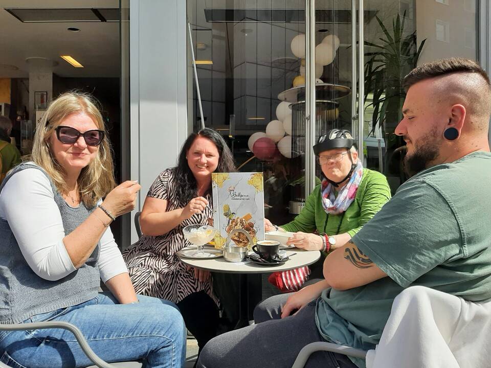 Bild sechs zeigt eine Gruppe Menschen vor der Eisdiele