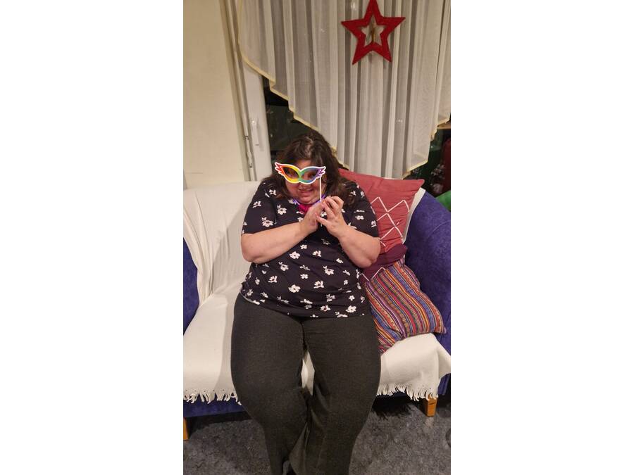 Frau hält sich eine Maske vor das Gesicht