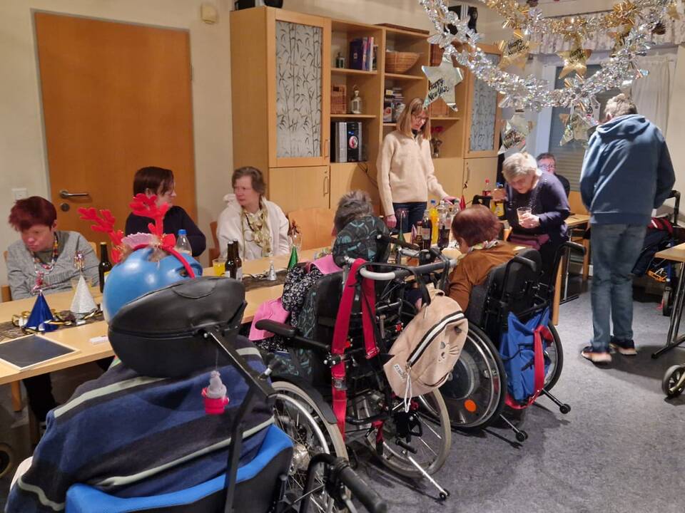 Gruppe sitzt an geschmückter Tafel im Speisesaal